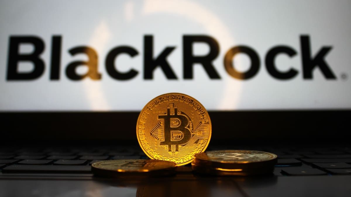 Een afbeelding van fysieke bitcoin munten voor een laptop met het BlackRock logo erop