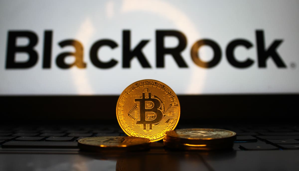 Een afbeelding van fysieke bitcoin munten voor een laptop met het BlackRock logo erop