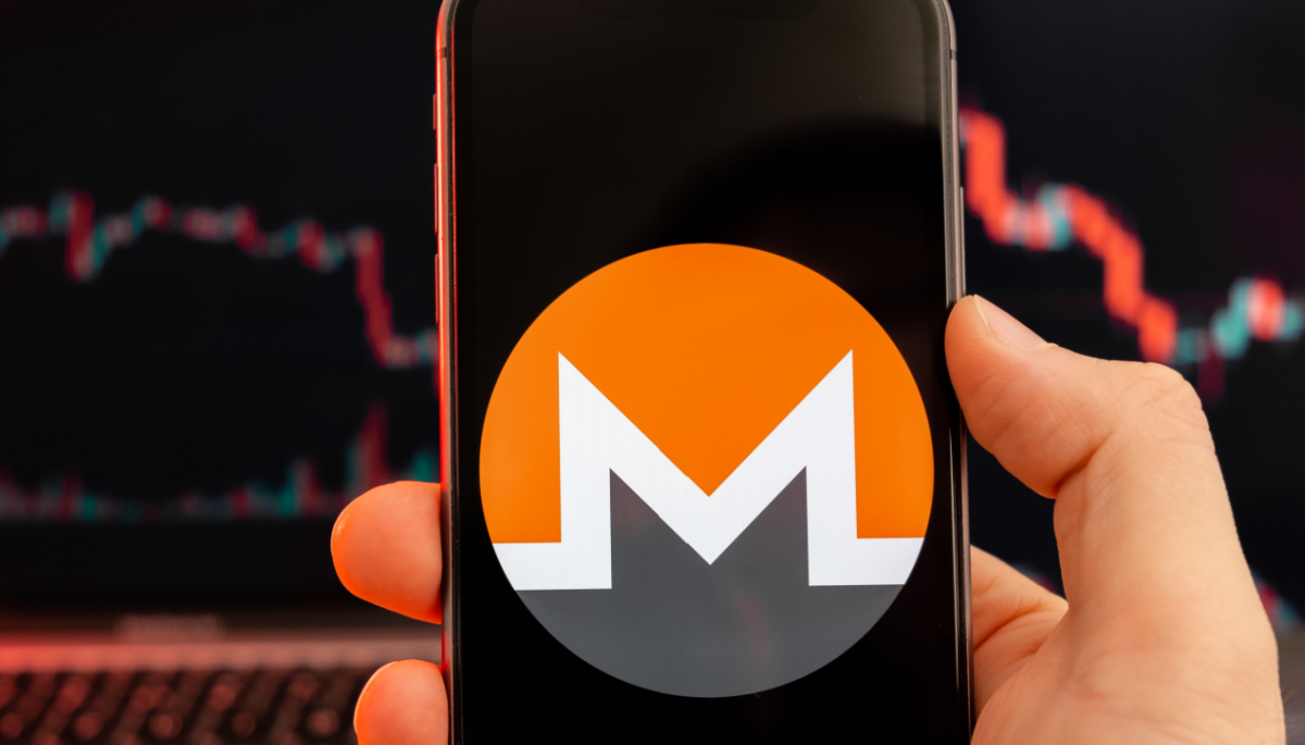 Monero logo op mobiel met koersgrafiek
