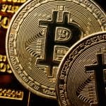 Een afbeelding van bitcoin (BTC) munten op goudstaven