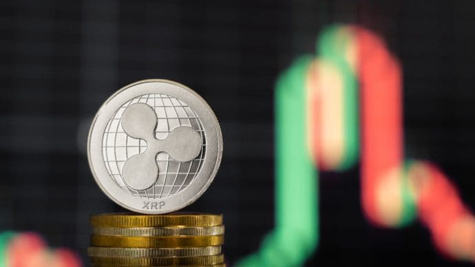 Een afbeelding van een Ripple_XRP munt met op de achtergrond een grafiek van de koers van XRP
