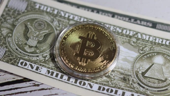 Een afbeelding van een bitcoin munt op een dollar biljet
