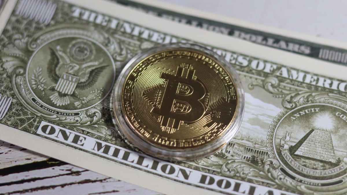 Een afbeelding van een bitcoin munt op een dollar biljet