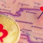 Een afbeelding van een gouden bitcoin (BTC) munt op een kaart met een pin bij kazachstan