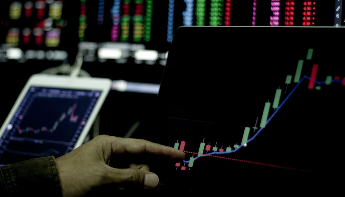 Een afbeelding van een handelaar die een stijgende koers van een crypto of aandeel aan het analyseren is
