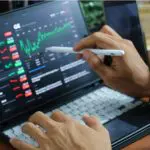 Een afbeelding van een investeerder die financiele gegevens op een laptop analyseert