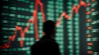 Een afbeelding van een scherm met stijgende koersen van crypto of aandelen voor het silhouet van een handelaar