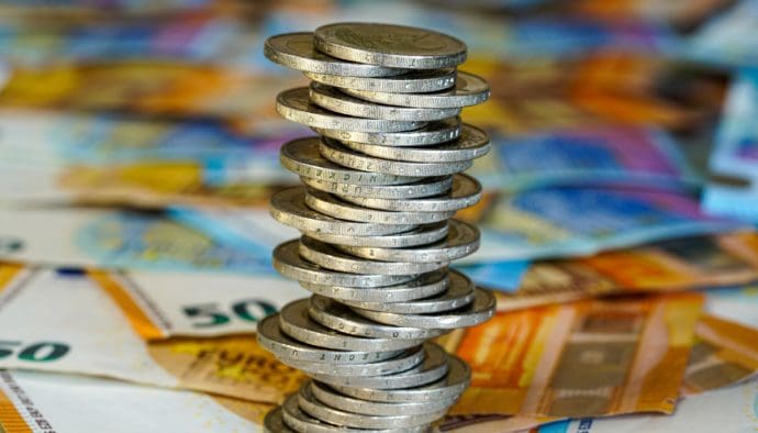 Een afbeelding van een toren van twee euromunten uit de EU, met daaronder briefgeld van 50 euro