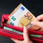 Een afbeelding van geld (euro bankbiljetten) die uit een portemonnee worden gehaald