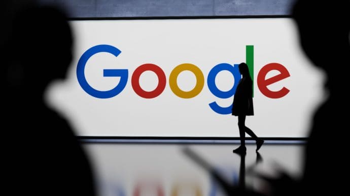 Een afbeelding van het Google logo op de achtergrind van een paar lopende mensen