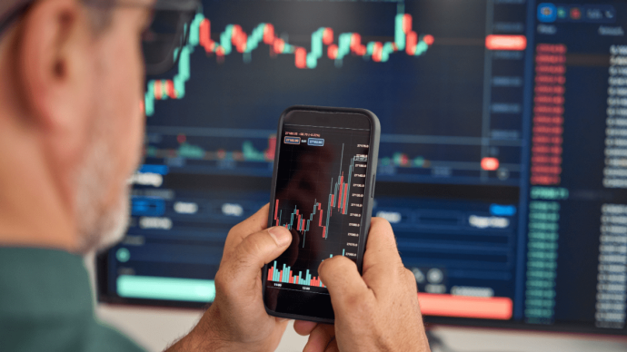 afbeelding van cryptotrader met mobiel en koersgrafiek