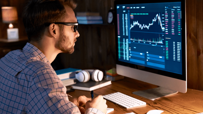 crypto trader achter scherm met koersgrafiek
