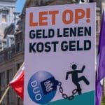 Een afbeelding van 'Let op! Geld Lenen Kost Geld' met DUO afgebeeld als blok aan het been voor vele studenten