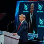 Een afbeelding van de Amerikaanse president Donald Trump die spreekt op een conferentie