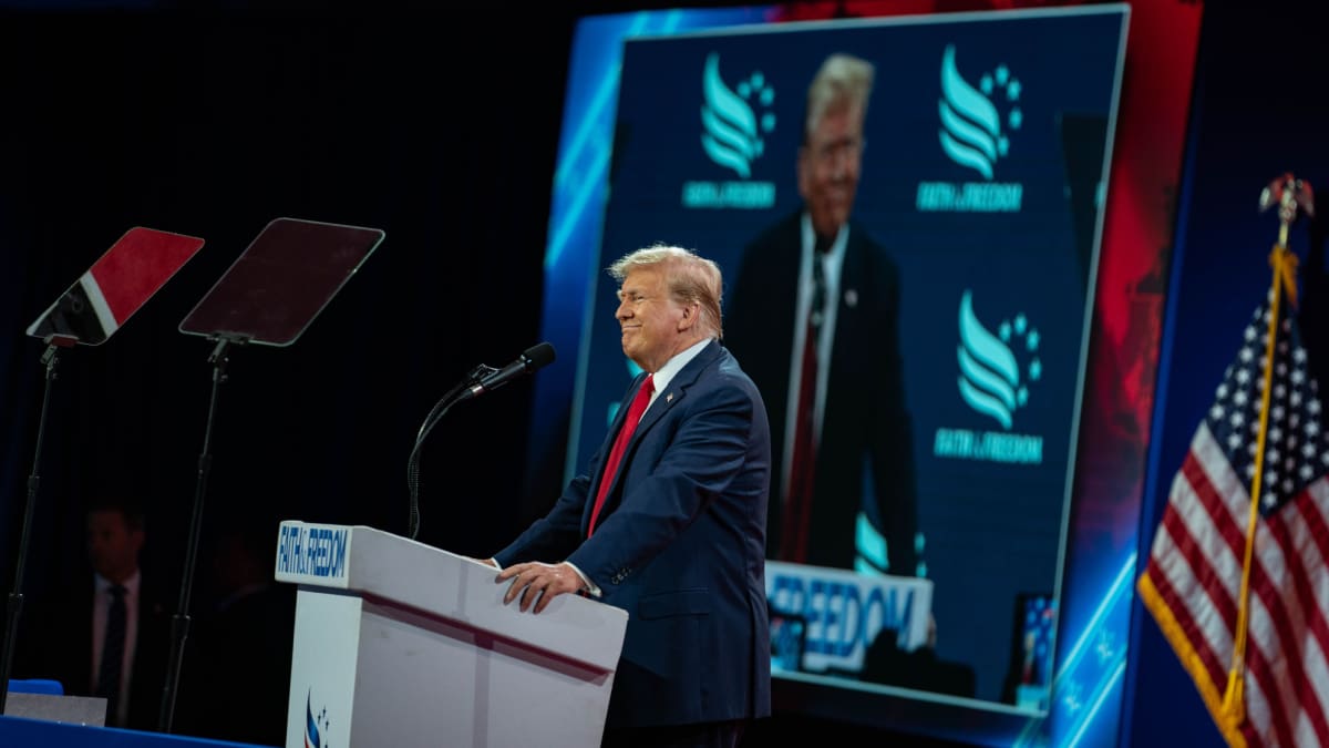 Een afbeelding van de Amerikaanse president Donald Trump die spreekt op een conferentie