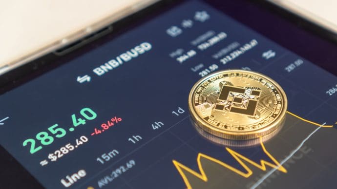 Een afbeelding van de cryptomunt BNB met daarbij een een koers en een grafiek op de pagina van de token op een cryptobeurs