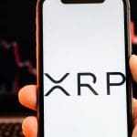 Een afbeelding van de cryptomunt XRP, met op de achtergrond een dalende koers