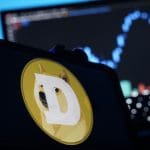 Een afbeelding van de cryptomunt dogecoin (DOGE) met daarbij het logo met de kenmerkende shiba inu mond, en op de achtergrond een grafiek van de koers Een afbeelding van de cryptomunt dogecoin (DOGE) met daarbij het logo met de kenmerkende shiba inu mond, en op de achtergrond een grafiek van de koers