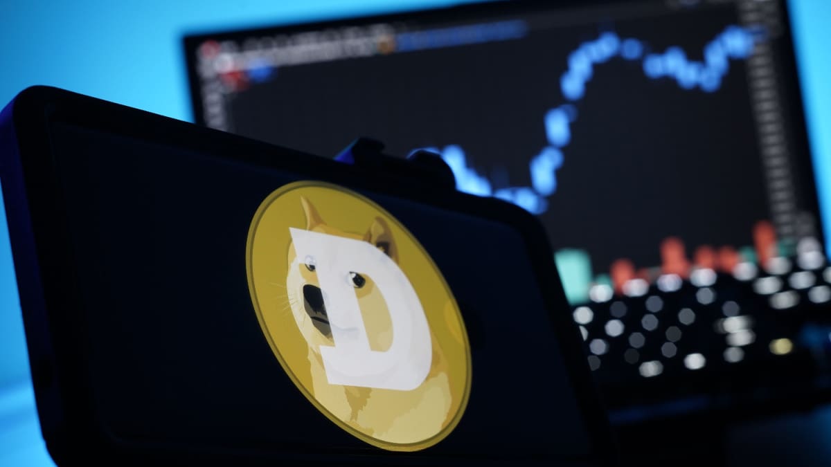 Een afbeelding van de cryptomunt dogecoin (DOGE) met daarbij het logo met de kenmerkende shiba inu mond, en op de achtergrond een grafiek van de koers Een afbeelding van de cryptomunt dogecoin (DOGE) met daarbij het logo met de kenmerkende shiba inu mond, en op de achtergrond een grafiek van de koers