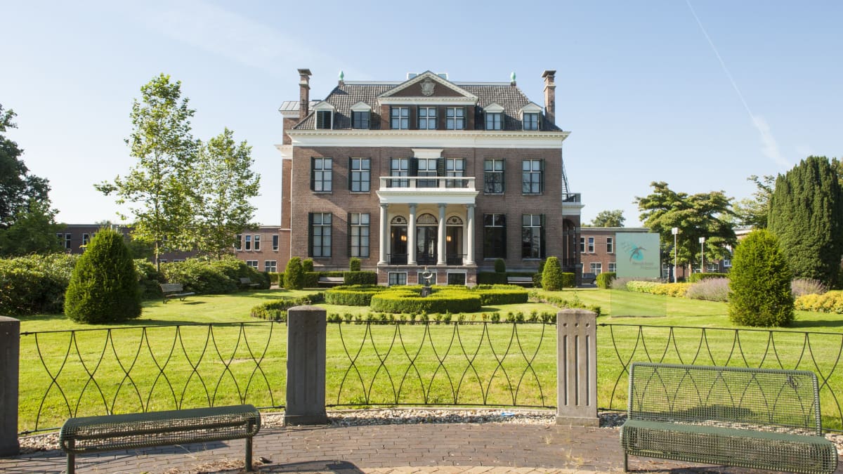 Een afbeelding van een Nederlandse villa met een grote tuin