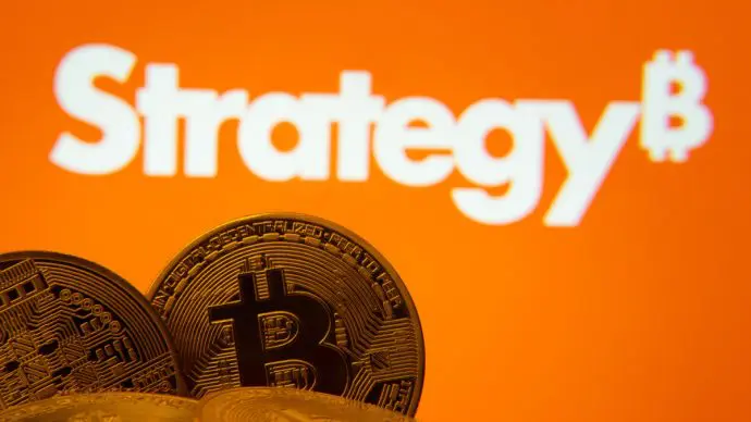 Een afbeelding van een aantal bitcoin munten met op de achtergrond het logo van Strategy, het bedrijf met de meeste bitcoin