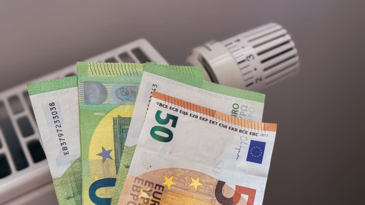 Een afbeelding van een aantal euro banbiljetten bij een verwarming, die het betalen van de energierekening moeten vertegenwoordigen