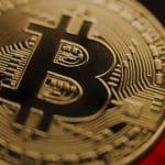 Een afbeelding van een bitcoin (BTC) die wordt vastgehouden, close-up die scherp inzoomt op de bitcoin