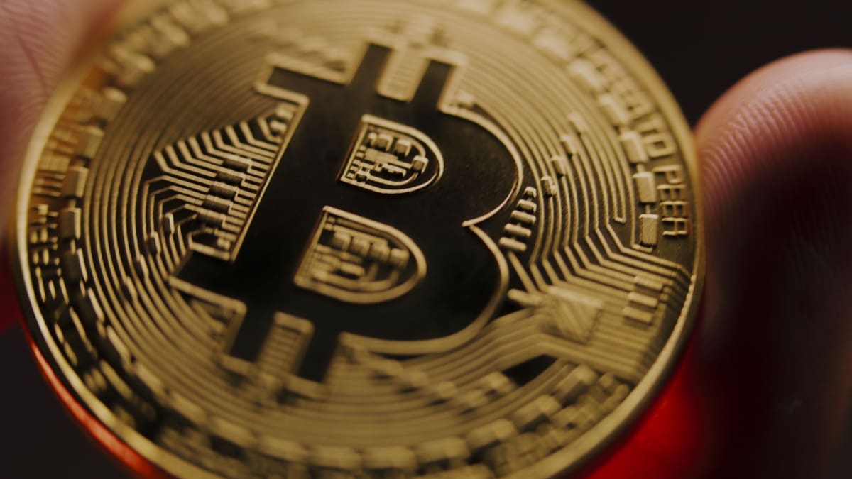 Een afbeelding van een bitcoin (BTC) die wordt vastgehouden, close-up die scherp inzoomt op de bitcoin