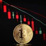 Een afbeelding van een bitcoin (BTC) munt met op de achtergrond een dalende koers Een afbeelding van een bitcoin (BTC) munt met op de achtergrond een dalende koers