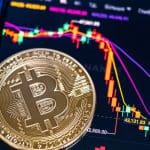 Een afbeelding van een bitcoin munt op een cryptobeurs met daarbij een bijbehorende grafiek en koers die hard crasht