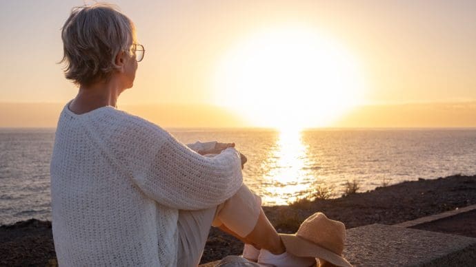 Een afbeelding van een gepensioneerde op het strand_de kade bij een zee met op de achtergrond een zonsondergang Een afbeelding van een gepensioneerde op het strand_de kade bij een zee met op de achtergrond een zonsondergang