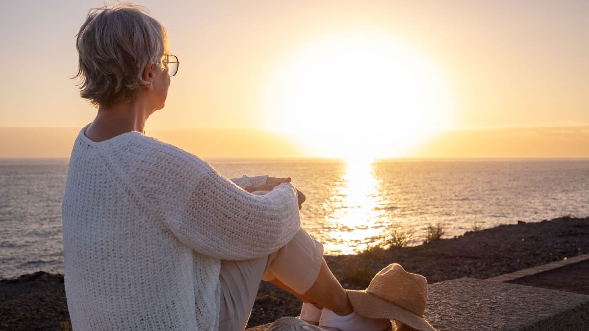Een afbeelding van een gepensioneerde op het strand_de kade bij een zee met op de achtergrond een zonsondergang Een afbeelding van een gepensioneerde op het strand_de kade bij een zee met op de achtergrond een zonsondergang