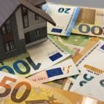 Een afbeelding van een huis op een stapel euro bankbiljetten