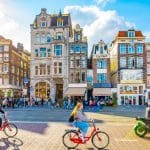 Een afbeelding van fietsende Nederlanders en toeristen in Amsterdam, de hoofdstad van Nederland Een afbeelding van fietsende Nederlanders en toeristen in Amsterdam, de hoofdstad van Nederland