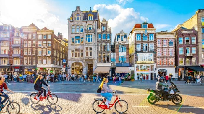 Een afbeelding van fietsende Nederlanders en toeristen in Amsterdam, de hoofdstad van Nederland Een afbeelding van fietsende Nederlanders en toeristen in Amsterdam, de hoofdstad van Nederland