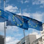 Een afbeelding van vlaggen van de Europese Unie bij hun hoofdkwartier in Brussel