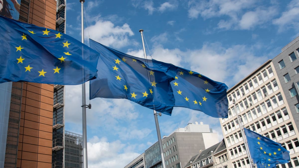Een afbeelding van vlaggen van de Europese Unie bij hun hoofdkwartier in Brussel