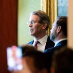 De Amerikaanse president van Financiën, Scott Bessent, te zien in het Witte Huis door een kier in gesprek met JD Vance