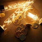 Een afbeelding van bitcoin (BTC) munten tussen een aantal brandende lampen