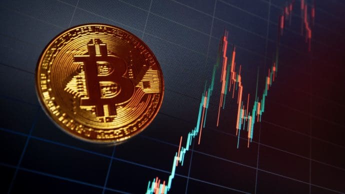 Een afbeelding van een bitcoin (BTC) munt met daarbij een stijgende koersgrafiek