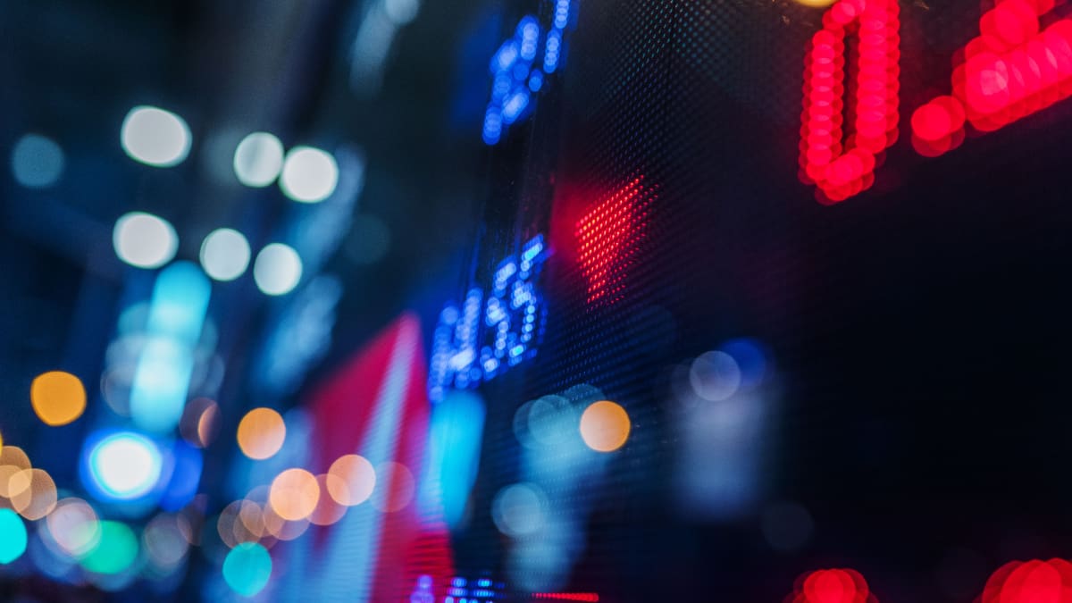 Een afbeelding van een bord met aandelen met daarop rode cijfers