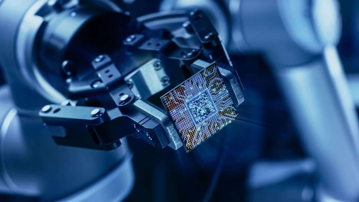 Een afbeelding van een computerchip, mogelijk die van een quantum computer, die wordt vastgehouden door een robotarm