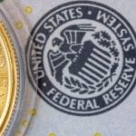 Een afbeelding van een stempel van de federal reserve naast een gouden munt