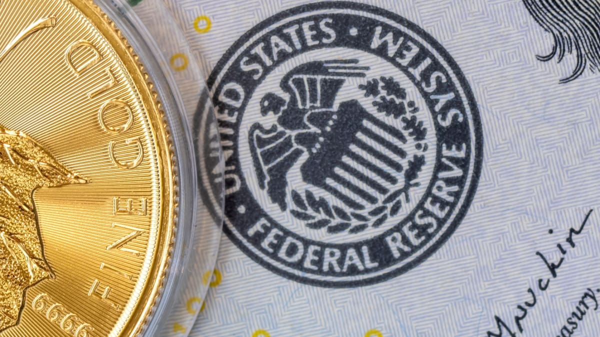 Een afbeelding van een stempel van de federal reserve naast een gouden munt