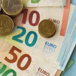 Een afbeelding van euromunt op een stapeltje euro bankbiljetten