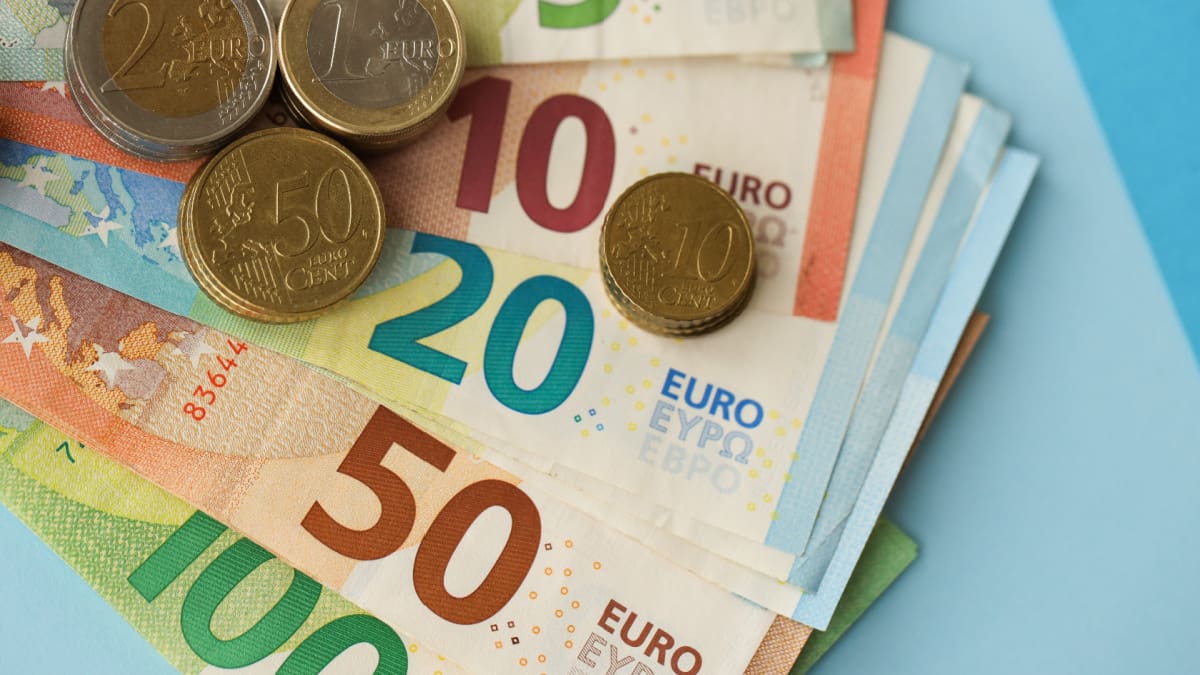Een afbeelding van euromunt op een stapeltje euro bankbiljetten