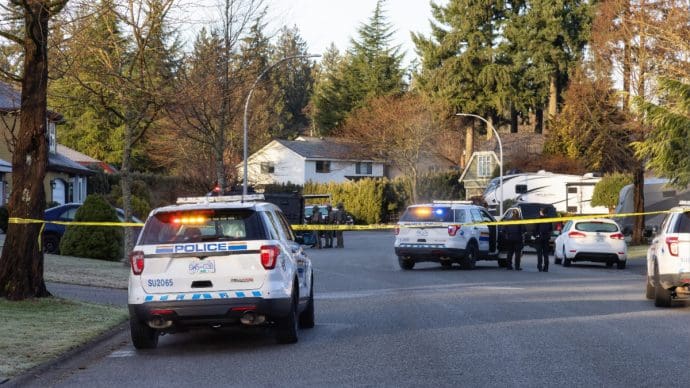 Politie met auto's en een SWAT team bij een huis in de suburbs van British Columbia