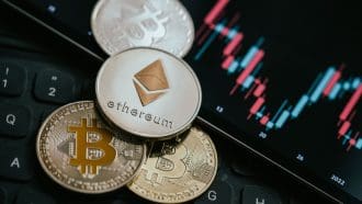 Een afbeelding van een ethereum munt met een aantal bitcoin munten met op de achtergrond een koers