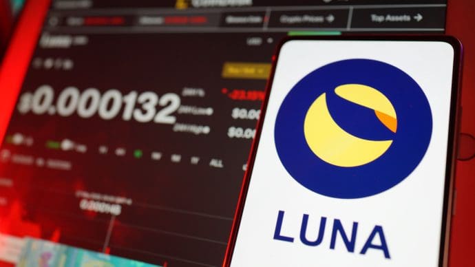 Een afbeelding van het logo van Terra (Luna) met op de achtergrond een koers en een grafiek op een coinpagina van de munt