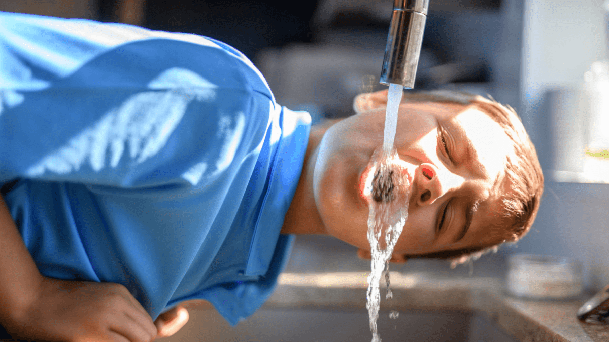 Jongen dringt water uit kraan